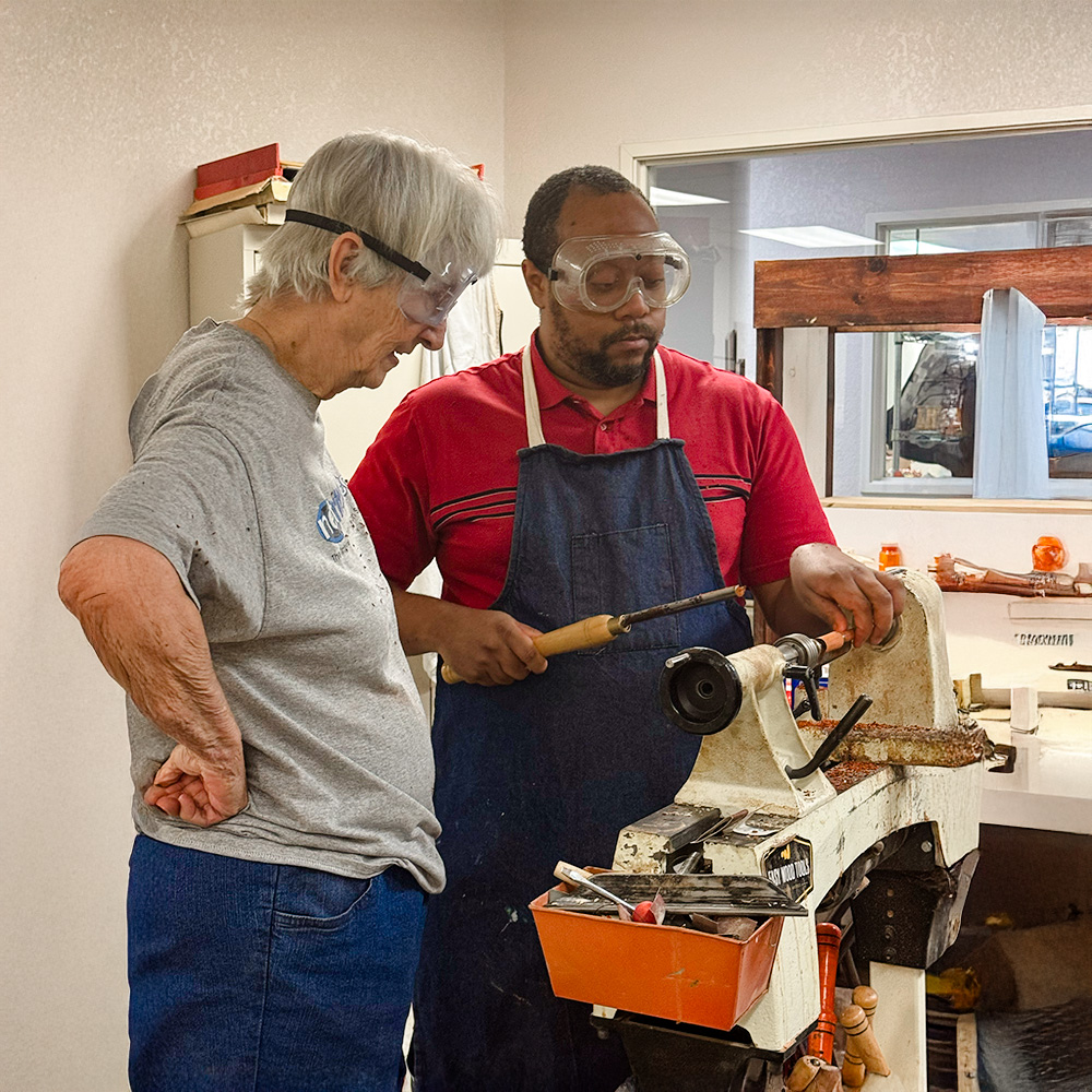 two people using a lathe